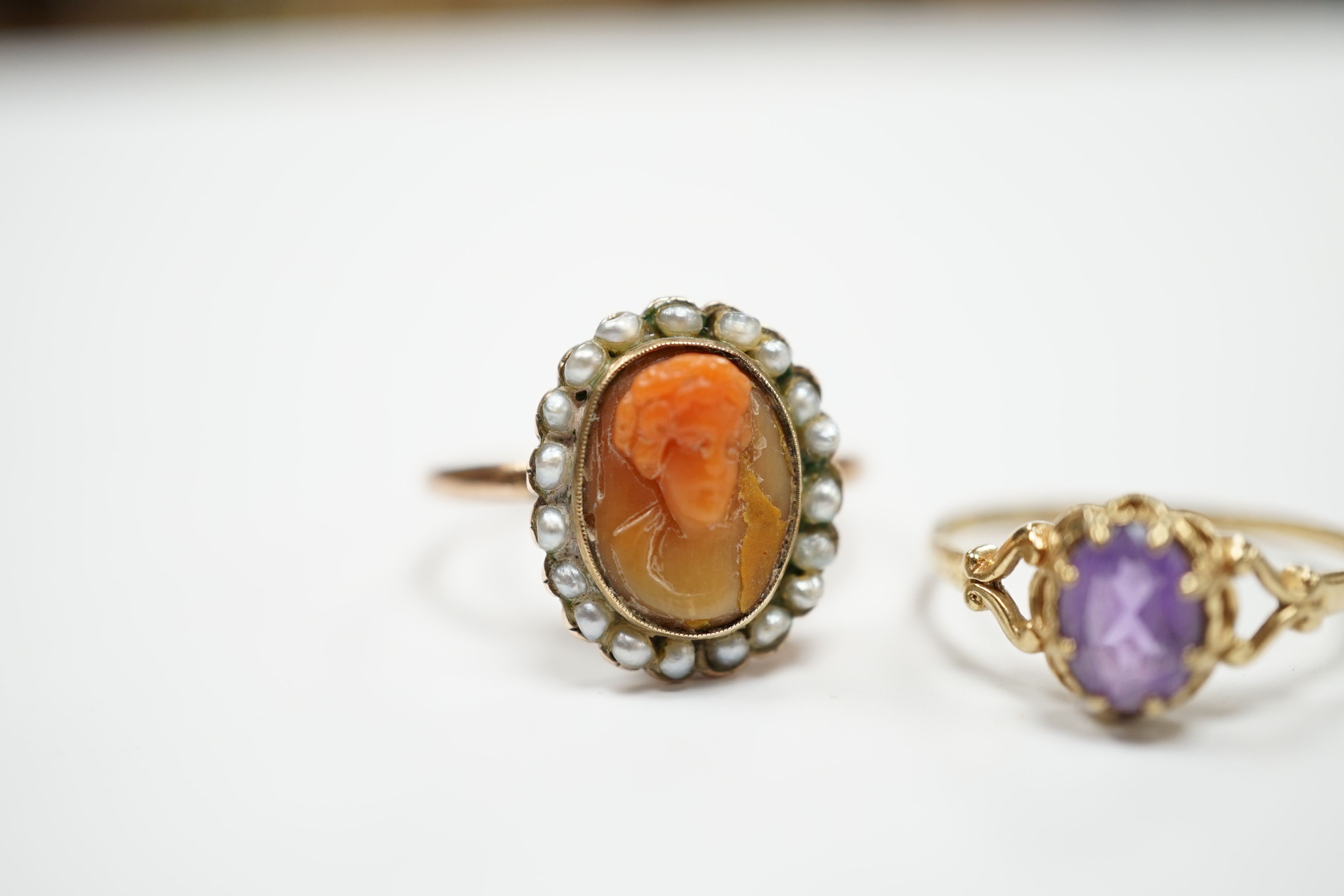 A modern 9ct gold and single stone amethyst set ring and a yellow metal, carved coral and split pearl set ring.